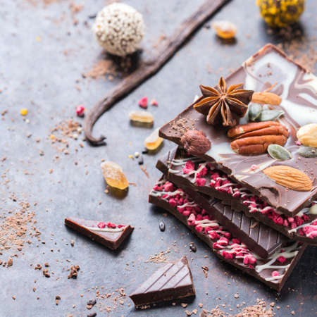 Assortment of chocolate bar and praline truffle with spices on black moody grunge tableの写真素材