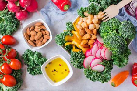 Health care, diet and nutrition concept. Buddha bowl, salad ingredients with vegetables and almond nuts, vegetarian vegan raw balanced detox meal food. Top view flat lay overheadの写真素材