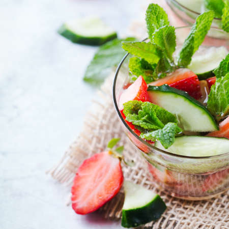 Healthcare, fitness, healthy nutrition concept. Fresh cool cucumber strawberry mint infused water, cocktail, detox drink, lemonade for spring summer daysの写真素材