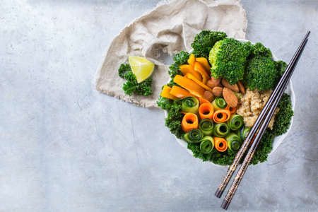 Health care, diet and nutrition concept. Buddha bowl with chopsticks on a rustic table, vegetarian vegan raw balanced detox meal food. Copy space background, top view flat lay overheadの写真素材