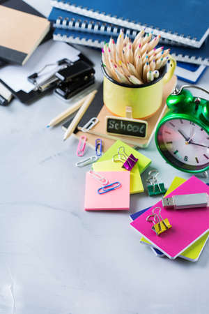 Back to school, children education concept. Assortment of supplies, crayons, pens, chalks, alarm clock. Copy space backgroundの写真素材