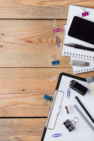 Business, education, office still life concept. Accessories, supplies, stationery, phone on rustic wooden table. Selective focus, flat lay, top view, copy space backgroundの写真素材