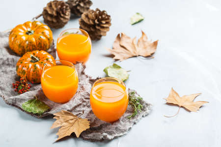 Food and drink, seasonal autumn thanksgiving concept. Pumpkin fresh juice drink cocktail on a table with fall decoration. Copy space backgroundの写真素材