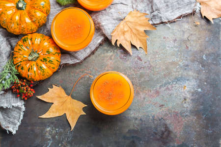 Food and drink, seasonal autumn thanksgiving concept. Pumpkin fresh juice drink cocktail on a rusty table with fall decoration. Copy space background, top view flat layの写真素材