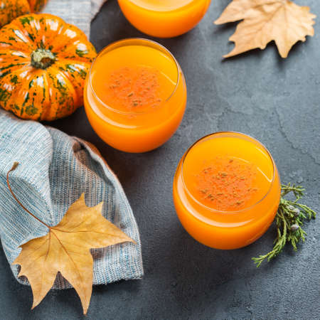 Food and drink, seasonal autumn thanksgiving concept. Pumpkin fresh juice drink cocktail on a black table with fall decorationの写真素材
