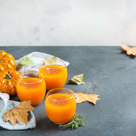Food and drink, seasonal autumn thanksgiving concept. Pumpkin fresh juice drink cocktail on a black table with fall decoration. Copy space backgroundの写真素材