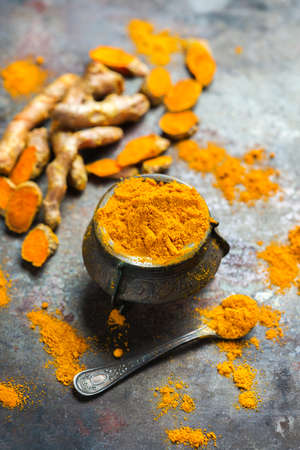 Food and drink, diet nutrition, health care concept. Organic orange turmeric root and powder, curcuma longa on a grunge cooking table. Indian oriental low cholesterol spicesの写真素材