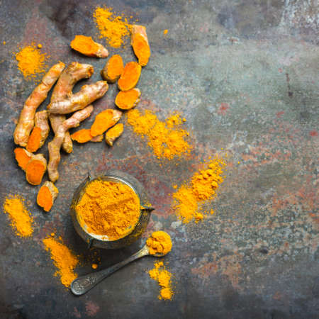 Food and drink, diet nutrition, health care concept. Organic orange turmeric root and powder, curcuma longa on a grunge cooking table. Indian oriental low cholesterol spices. Top view flat layの写真素材