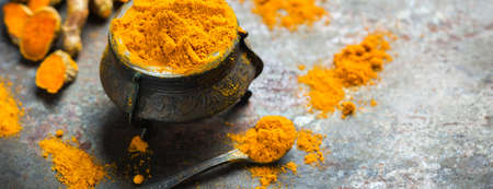 Food and drink, diet nutrition, health care concept. Organic orange turmeric root and powder, curcuma longa on a grunge cooking table. Indian oriental low cholesterol spicesの写真素材