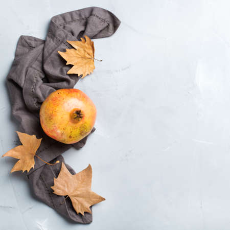 Autumn fall harvest concept. Ripe juicy pomegranate on a cozy kitchen table. Copy space background, top view flat layの写真素材