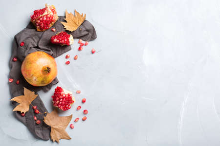 Autumn fall harvest concept. Ripe juicy pomegranate on a cozy kitchen table. Copy space background, top view flat layの写真素材