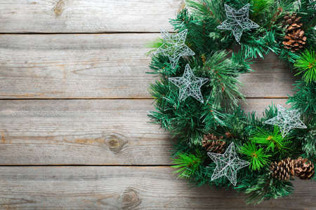 Holidays new year concept. Advent christmas door wreath with festive decoration on a cozy wooden background. Copy space flat lay top view