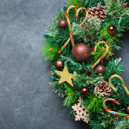 Holidays new year concept. Advent christmas door wreath with festive decoration on a cozy black background. Copy space flat lay top viewの写真素材