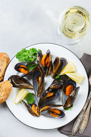 Still life, restaurant dinner. Shellfish mussels with lemon and green parsley with white wine. Seafood on a concrete table. Flat lay top view backgroundの写真素材