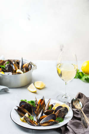 Still life, restaurant dinner. Shellfish mussels with lemon and green parsley with white wine. Seafood on a concrete table. Copy space backgroundの写真素材