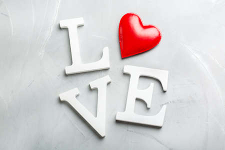 Love and still life concept. Valentines day holiday text with red heart. Copy space trendy...