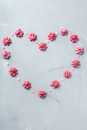 Love and still life concept. Valentines day holiday card with pink meringue heart. Trendy copy space background, top view flat layの写真素材