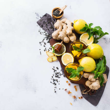 Japanese chinese tea teapot lemon ginger honey mint on a white cozy table. Warm drink beverage...