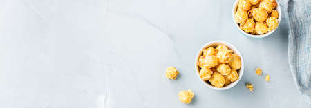 Junk sweet food concept. Caramel popcorn in blue glasses ready for party and cinema. Copy space top view flat lay backgroundの写真素材
