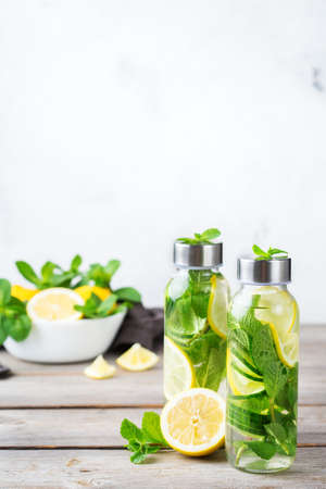 Health care, fitness, healthy nutrition diet concept. Fresh cool lemon cucumber mint infused water, cocktail, detox drink, lemonade in a glass jar for spring summer days. Copy space backgroundの写真素材