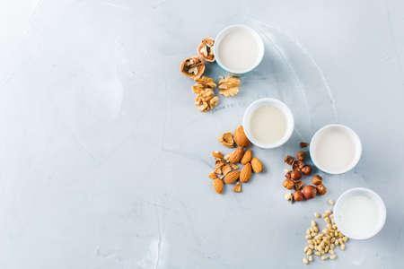 Food and drink, health care, diet and nutrition concept. Assortment of organic vegan non diary milk from nuts in glasses on a kitchen table. Copy space top view flat lay backgroundの写真素材
