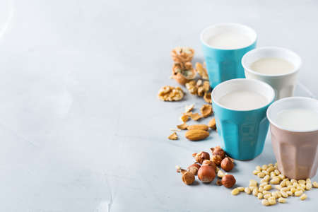 Food and drink, health care, diet and nutrition concept. Assortment of organic vegan non diary milk from nuts in glasses on a kitchen table. Copy space backgroundの写真素材