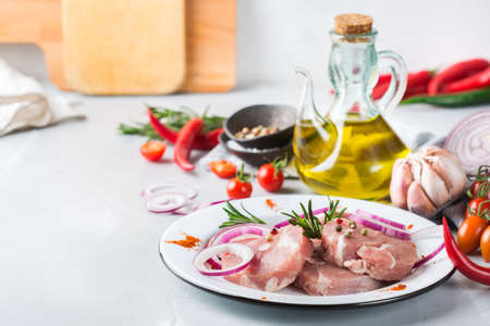 Fresh raw organic farmer pork with spices ready for cooking on a kitchen tableの写真素材