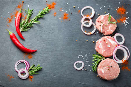 Fresh raw organic farmer pork with spices ready for cooking on a kitchen table. Top view flat lay backgroundの写真素材