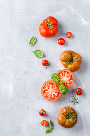 Food, harvesting, summer concept. Assortment of ripe organic farmer red tomatoes on a kitchen table. Top view flat lay backgroundの写真素材