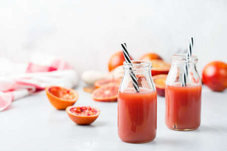 Food and drink, health care, diet and nutrition concept. Fresh red blood orange juice from ripe organic citrus fruits in a bottle for breakfast on a kitchen table. Spring summer beverageの写真素材