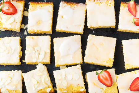 Food, breakfast teatime concept. Homemade lemon polenta cookie bars with white icing on a kitchen table. Top view flat lay backgroundの写真素材
