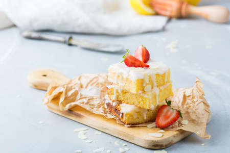 Food, breakfast teatime concept. Homemade lemon polenta cookie bars with white icing on a kitchen tableの写真素材
