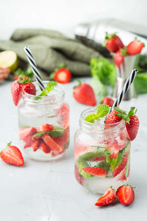 Food and drink, holidays party concept. Cold fresh alcohol beverage mojito cocktail with white rum, soda, red strawberry and basil for refreshment in summer daysの写真素材