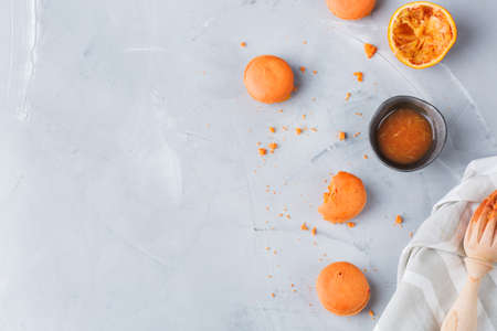 Food and drink, sweet romantic food concept. Handmade orange macaroons on a modern table. Top view flat lay copy space backgroundの写真素材