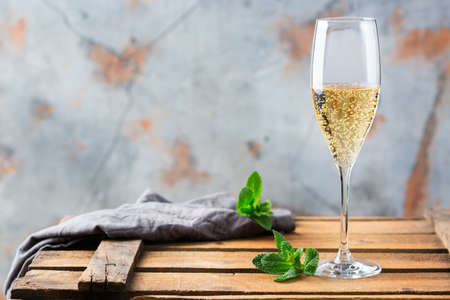 Food and drink, holidays party concept. Cold fresh alcohol beverage champagne sparkling white wine with bubbles in a flute glass on a wooden table. Copy space backgroundの写真素材