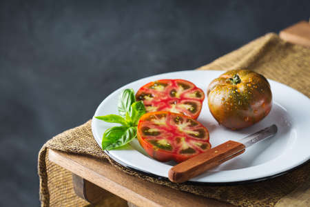 Food, harvesting, summer concept. Assortment of red ripe organic farmer tomatoes on a kitchen table. Copy space dark backgroundの写真素材