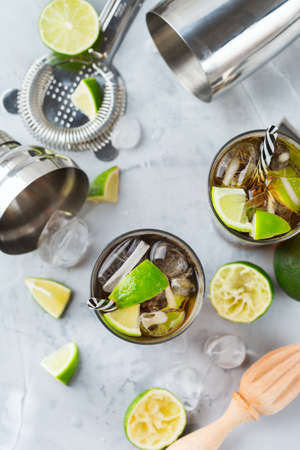 Food and drink, holidays party concept. Cuba libre or long island iced tea alcohol cocktail drink beverage, longdrink in a glass with straw, ice and lime on a table. Top view flat lay backgroundの写真素材