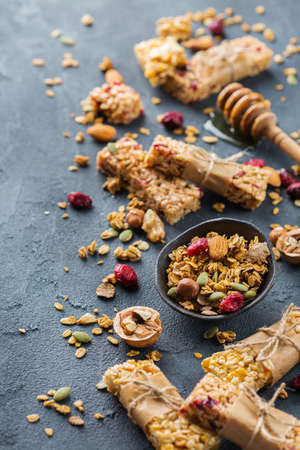 Food and drink, dieting, nutrition breakfast concept. Healthy homemade cereal granola muesli bars with oats, nuts, dry berries on a cozy kitchen tableの写真素材