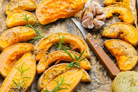 Baked roasted grilled orange pumpkin butternut squash and sweet potato with herbs. Autumn food, soup ingredients. Kitchen backgroundの写真素材