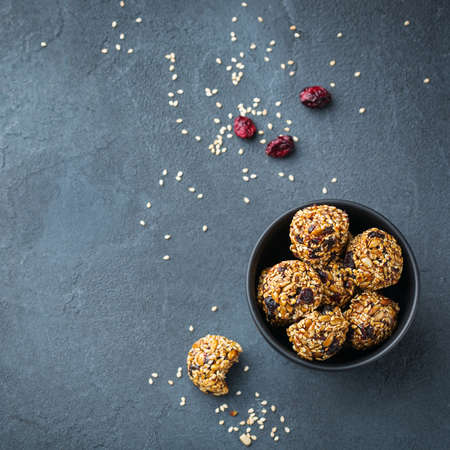 Food and drink, healthy lifestyle, eating, diet and nutrition, snack, superfood concept. Handmade raw vegan protein energy balls with sesame seeds, dry cranberry, nuts, honey.   backgroundの写真素材
