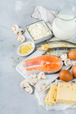 Balanced diet nutrition, healthy eating concept. Assortment of food sources rich in vitamin d, salmon, dairy products, milk, eggs, cheese, mushrooms, sardines on a kitchen tableの写真素材
