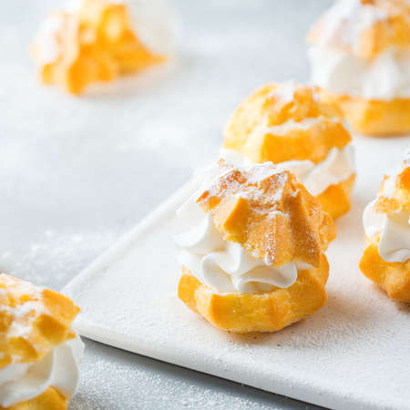 Food and drink, holidays concept. Delicious sweet homemade profiteroles with cream on a modern...