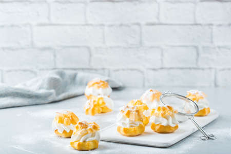 Food and drink, holidays concept. Delicious sweet homemade profiteroles with cream on a modern...