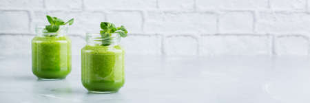 Food and drink, healthy dieting and nutrition, lifestyle, vegan, alkaline, vegetarian concept. Green smoothie with organic ingredients, vegetables on a modern kitchen table. Copy space backgroundの写真素材