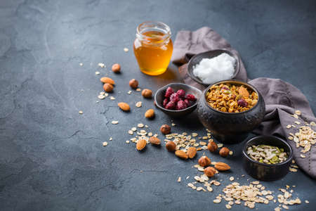 Healthy eating, dieting and nutrition, fitness, balanced food, breakfast concept. Homemade granola muesli with ingredients on a table. Copy space backgroundの写真素材