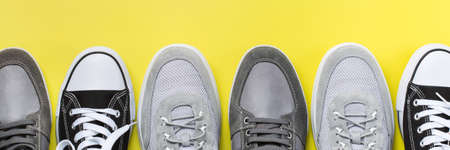 Fashion, blog, blogging, lifestyle, well-being trendy concept. Set of male shoes, sneakers on yellow background, top view, flat layの写真素材