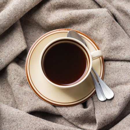 Autumn, fall, winter home decor in scandinavian, hygge style. Seasonal composition with cup of coffee, warm woolen scarf, soft plaid on a rustic wooden table. Flat lay backgroundの写真素材