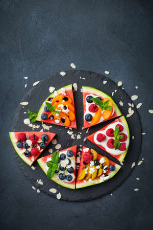 Healthy clean eating, dieting and nutrition, seasonal, summer concept. Watermelon pizza with berries, fruits, yogurt, feta cheese on a table. Top view flat lay copy space background.の写真素材