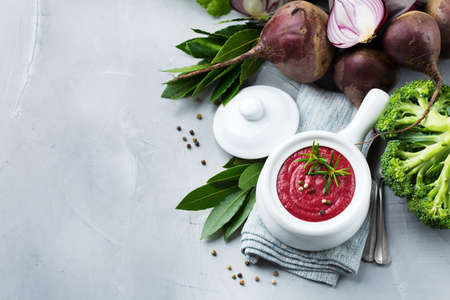 Healthy food, clean eating concept. Seasonal fall autumn vegetables creamy beetroot soup with ingredients on a kitchen table. Top view flat lay copy space backgroundの写真素材