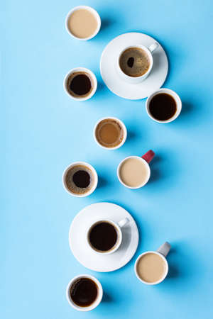 Assortment of coffee cups and mugs with black roasted, americano, cappuccino, milk on a blue background. Creative trendy flat layの写真素材